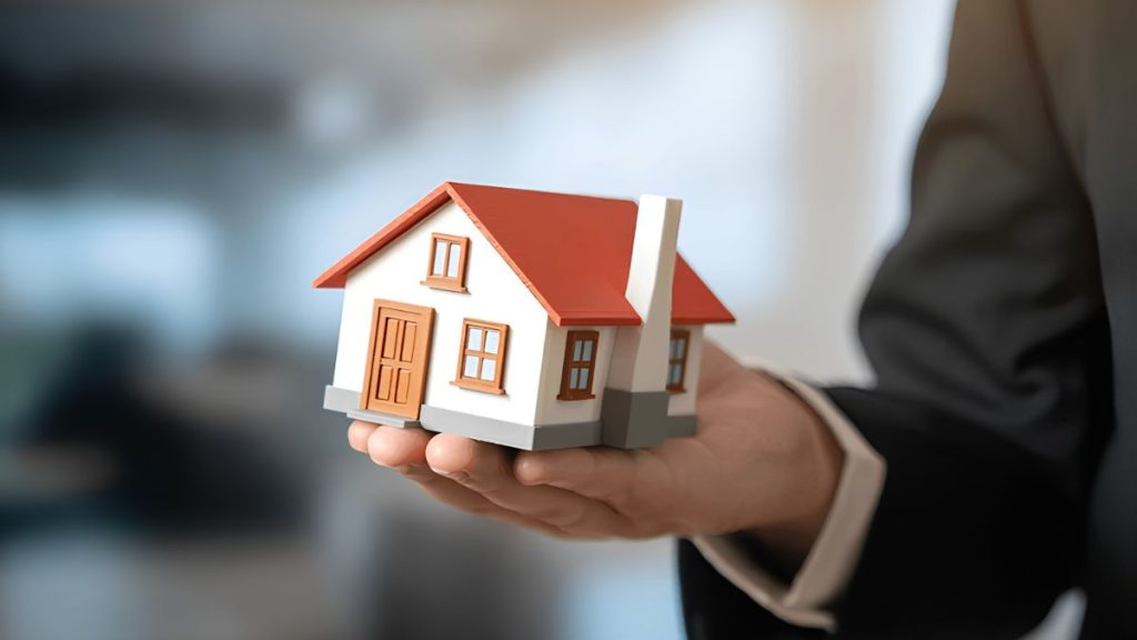 Cateo-quantium-desarrollos-pedro-dávila - Hola Mty Person in a Suit Holding a Small Model House, Symbolizing Real Estate or Home Ownership. - Hola Mty