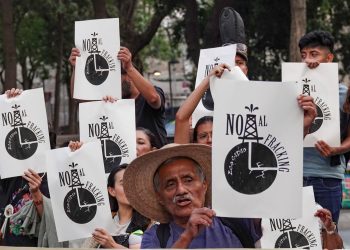 Crowd of Protesters Holding White Signs Reading 'no Al Fracking' with a Black Oil Rig Graphic. - Hola Mty