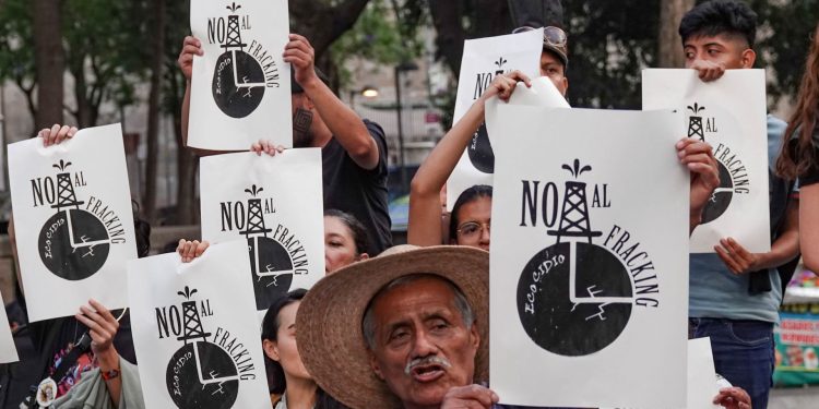 Crowd of Protesters Holding White Signs Reading 'no Al Fracking' with a Black Oil Rig Graphic. - Hola Mty